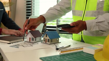 Wall Mural - Architects and consultants of a housing development are discussing the structure and layout of a house,Two engineers are having a meeting about a problem that has arisen in the blueprints