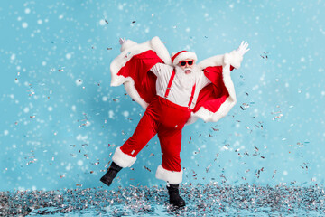 Wall Mural - Full length photo of retired old man grey beard crazy club dance raise hands confetti wear santa x-mas costume suspender boots sunglass cap boot pants isolated blue color background