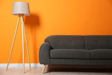 Canvas Print - Stylish sofa and floor lamp near orange wall