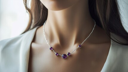 A refined woman wearing a silver necklace with delicate amethyst and aquamarine stones, the gemstones glowing softly under natural light.