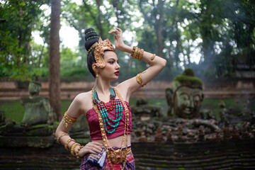 Beautiful young ASEAN woman in traditional Thai Dvaravati dress in an old temple in Chiang Mai, Thailand.