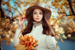 © Oleg Gekman - Autumn portrait of a beautiful happy smiling woman with yellow maple leaves in a white coat in the park