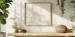 © Kamonwan - Stylish interior featuring a blank frame on a table with plants and natural light casting shadows, perfect for home decor inspiration.