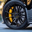 © สมชัย ้พาลแก้ว - Close up shot of black light alloy wheels with yellow brake disc pad, low-profile tires of a car.