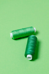 Top view of thread spools on green background