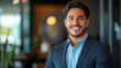 © ASSIASIA - Smiling elegant confident young professional Latino hispanic business man , male proud leader, smart Latin businessman lawyer or company manager executive looking at camera standing in office