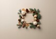 © joeycheung - A square frame with a beige background is surrounded by pine sprigs, pine cones, star anise, dried citrus, and Christmas ornaments.