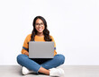 © OceanProd - young woman university student studying on the pc full body sitting smiling on white background