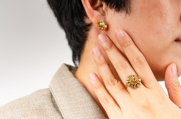 Young woman wearing stylish jewelry on white background  closeup