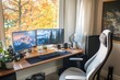 © Asraf - A remote home office setup with dual monitors, a comfortable chair, and office essentials