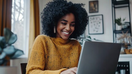 Poster - A smiling woman with curly hair enjoys using her laptop at home, dressed in a cozy sweater, surrounded by a warm and inviting environment.