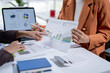 © Wasana - Two businesswomen analyzing financial charts and data on paperwork