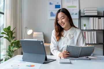 Wall Mural - asian accountant woman working with calculator and laptop at home office