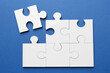 © New Africa - White puzzle pieces on blue background, top view