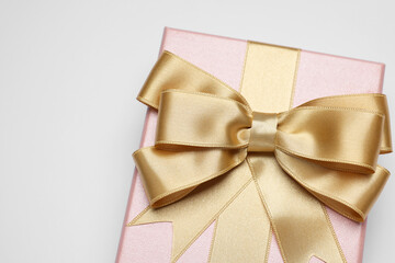 Sticker - Gift box with golden bow on light grey background, above view