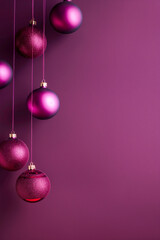 Wall Mural -  Festive magenta Christmas background with hanging ornaments. Christmas decorations with pink and purple baubles on a rich magenta background with copy space.
