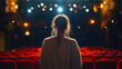 © Stefan - Rearview of a woman standing on an empty theater stage under a spotlight, preparing for a dramatic performance, passion and art talent as she rehearses for a classical theatrical spectacle or audition