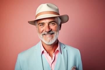 Poster - Portrait of a grinning man in his 50s donning a classic fedora while standing against pastel or soft colors background