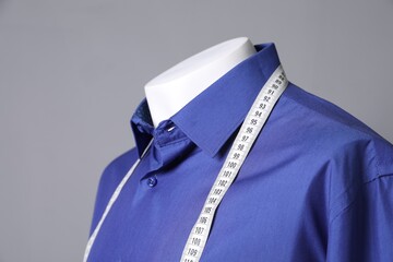 Sticker - Male mannequin with blue shirt and measuring tape on grey background, closeup