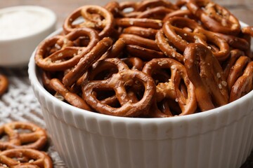 Wall Mural - Delicious salty pretzel crackers on wooden table, closeup