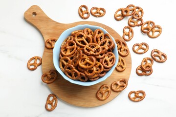 Wall Mural - Tasty pretzel crackers on white table, top view