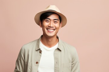 Poster - Portrait of a happy asian man in his 20s donning a classic fedora over pastel or soft colors background