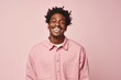 © Markus Schröder - Portrait of a joyful afro-american man in his 20s sporting a breathable hiking shirt over pastel or soft colors background