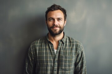 Canvas Print - Portrait of a satisfied man in his 30s dressed in a relaxed flannel shirt in minimalist or empty room background