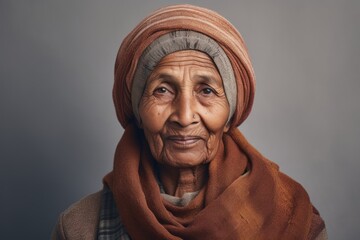 Canvas Print - Portrait of a tender indian woman in her 70s donning a warm wool beanie isolated on minimalist or empty room background