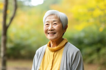 Sticker - Portrait of a smiling asian elderly woman in her 90s dressed in a breathable mesh vest isolated in minimalist or empty room background