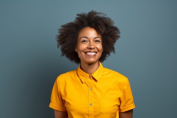 Wall Mural - Portrait of a grinning afro-american woman in her 50s sporting a technical climbing shirt over solid color backdrop