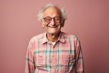 Poster - Portrait of a grinning man in his 70s dressed in a relaxed flannel shirt while standing against solid color backdrop