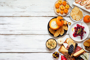 Aufkleber - Fall theme appetizer side border against a white wood background. Charcuterie board, pumpkin and apple dips, crostini, cheeses and snacks. Top view.
