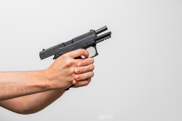 Close up of a person demonstrating holding a firearm / pistol with two hands shooting hands on the trigger