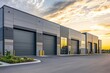 © Kenny - Modern industrial warehouse with large rolling doors at sunset