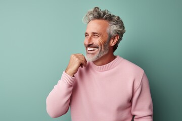 Poster - Portrait of a joyful man in his 50s wearing a cozy sweater in solid pastel color wall