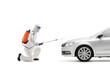 © Ljupco Smokovski - Man in a hazmat suit kneeling and disinfecting a car