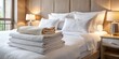 © Sandra - Crisp, freshly laundered white hotel linens, including a plush duvet, pillowcases, and towels, are neatly arranged on a luxurious bed, evoking comfort and relaxation.