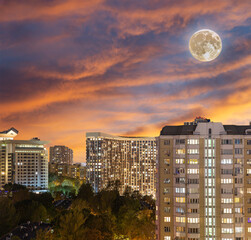 Aerial view of Moscow (night, against the sunset) and full moon, Cheryomushki district near Profsoyuznaya metro station, Russia