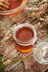 Wall Mural - Herbal syrup in a glass jar with fresh wild heather flowers on a wooden table