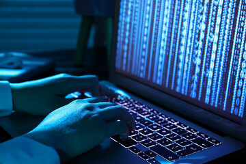 Poster - Female programmer typing on laptop keyboard at night in office, closeup