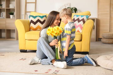 Wall Mural - Happy woman and her little son with bouquet of beautiful narcissus at home