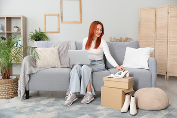 Poster - Young woman using laptop with new shoes at home