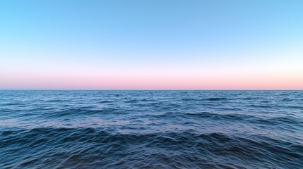 The ocean is calm and peaceful, with a beautiful blue sky in the background. The water is still, and the horizon is visible in the distance