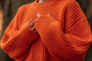 Wall Mural - Fashion details of warm knitted orange sweater, cozy autumn clothes concept