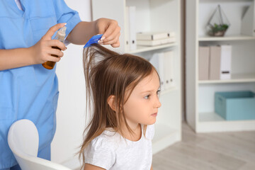 Poster - Female doctor combing little girl's hair with pediculosis in clinic