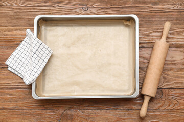 Canvas Print - Empty baking tray, rolling pin and napkin on wooden background