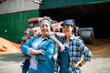 © Marko Geber - Two female farmers standing confidently in front of a tractor at the farm