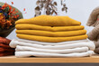 © ADDICTIVE STOCK - Neatly stacked colorful sweaters on a wooden table