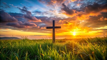 Large wooden cross is standing in a grass field with a beautiful sunset in the background